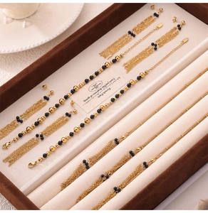 Detail view of vintage multi-layer gold chain necklace and beaded earrings set