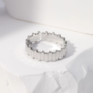 Close-up of minimalist silver stainless steel ring with irregular jagged edges on stone