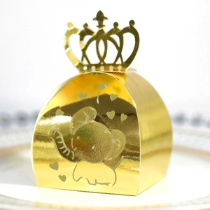 Detail of laser-cut crown candy box in gold finish with elephant and heart patterns