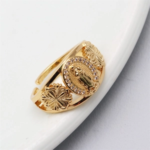 Macro view of gold-plated adjustable ring featuring religious figure and pavé zircons