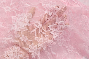 Vista detallada del encaje floral rosa que muestra la textura pura y patrones delicados