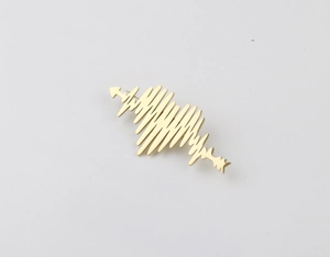 Macro detail of golden heartbeat brooch with arrow design on clean grey background