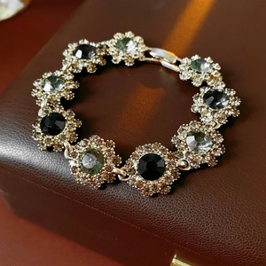 Macro view of vintage gold bracelet with black gemstones and crystals on leather box