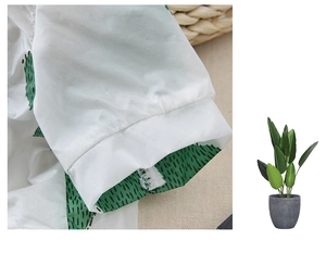 Detailed macro view of thin white pet shirt fabric with green cactus pattern prints