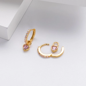 Macro shot of gold S925 silver hoop earrings with pink heart zircon stones and fine details