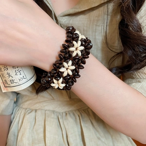 Detailed view of handcrafted ethnic coconut shell bead bracelet with flower patterns