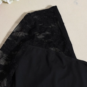 Dettaglio del tessuto patchwork in pizzo nero con texture intricate e design traforato