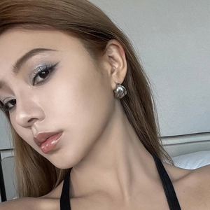 Triple-layer C-shaped silver metal hoop earrings with elegant twisted texture on model