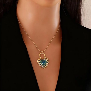 Collier avec pendentif serrure cœur doré et pierres bleues porté par un modèle