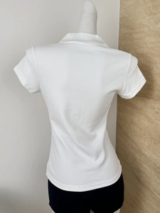 Detail view of the white polo shirt's textured fabric and polo collar from the back