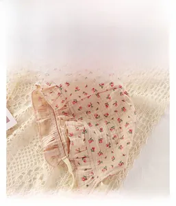 Detailed view of pink floral baby sun hat with ruffle brim and adjustable ties