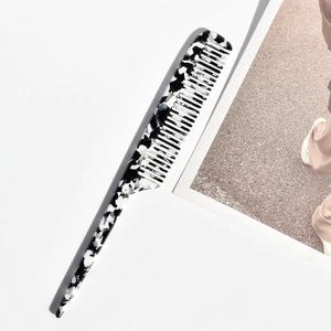 Makroaufnahme des schwarz-weißen Marmor-Stielkamms aus Acetat für professionelles Styling