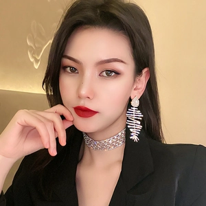 Boucles d'oreilles arête de poisson argentées et choker en strass sur un mannequin