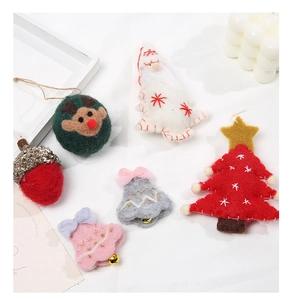 Macro detail of handmade Christmas wool felt ornaments with reindeer and tree charms