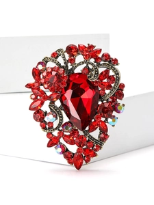 Close-up of vintage heart brooch with deep red gemstones and water drop center crystal