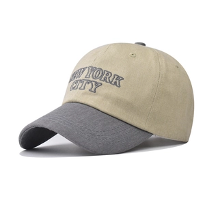 Detail of embroidered New York City text on khaki and grey cotton baseball cap