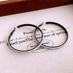 Minimalist black and white hoop earrings with ENICENIC letter print design