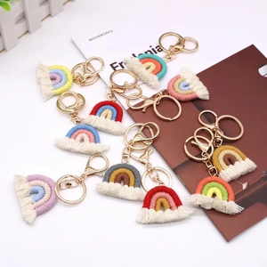 Handmade woven rainbow keychain with white cotton tassels and golden lobster clasp charms