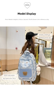 Detail of light blue checkered backpack with cute bear pattern and plush toy charm
