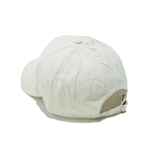 Détail de la boucle en métal et du jacquard LOVE gaufré sur la casquette blanche