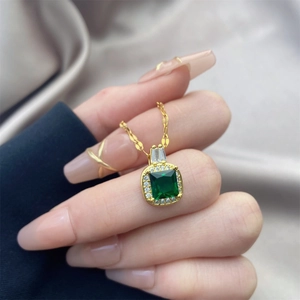 Détail du collier avec pendentif zircon vert émeraude et halo de diamants dorés
