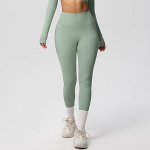 Detail of high-waisted yoga pants in light green featuring functional side pockets