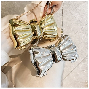Detailed view of gold and silver bow evening bags with metallic texture and chain straps