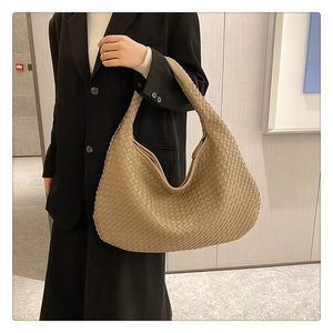 Khaki woven leather tote bag showcased on a black blazer for a sophisticated commute look