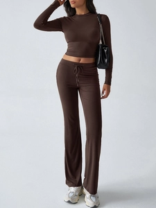 Detailed close-up of brown long sleeve crop top and matching flared trousers set