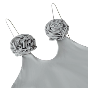 Détail des fleurs en tissu 3D sur une robe courte dos nu gris clair élégante