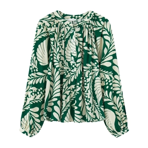Detail des grünen Blattmusters auf der Chiffonbluse mit feinem plissiertem Ausschnitt