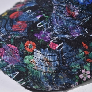 Detail of floral lace embroidery and distressed frayed edges on a baseball cap