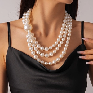 Detail of layered faux pearl necklace with a large statement pearl on a model's neck
