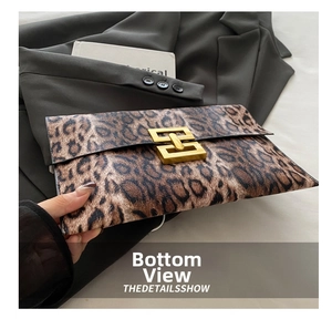 Detail view of the leopard print envelope bag with a metallic gold geometric buckle clasp