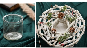 Detail of white festive wreath with pine cones and red berries on a green fabric backdrop