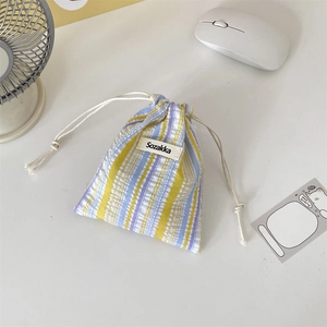 Close-up of pleated striped drawstring pouch with Sozakka label and cotton cord detail