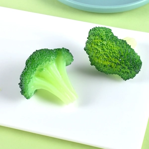 Realistic artificial broccoli models on white tray for food decoration and keychains