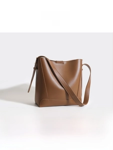 Detailed view of a brown leather bucket bag highlighting its sleek texture and design