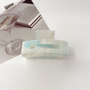 Detail of square blue and white gradient hair claw clip with subtle glitter finish