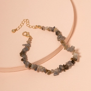 Bohemian irregular turquoise stone bracelet with adjustable gold lobster clasp on pedestal