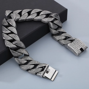 Close-up of vintage silver Cuban chain texture and square clasp on a metal bracelet