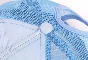 Close-up of the breathable blue mesh fabric and top button on a summer ponytail baseball cap