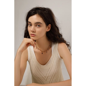 Close-up of 18K gold stainless steel necklace with small star charms worn by a model