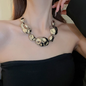Chunky silver crumpled metal bead necklace on model with elegant minimalist style