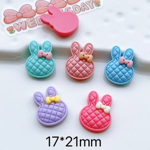 Macro detail of acrylic rabbit charms with quilted texture and bow for DIY crafts