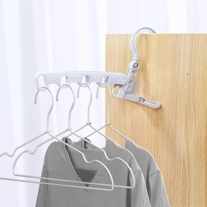Foldable 5-hole clothes hanger in white plastic showing mounting on wooden furniture