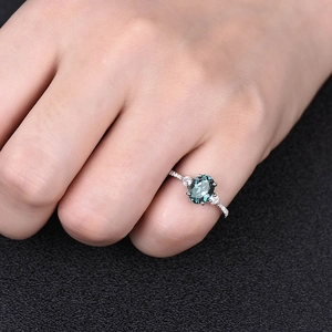 Elegante driestenen ring met ovale blauwgroene edelsteen en diamanten op zilveren band