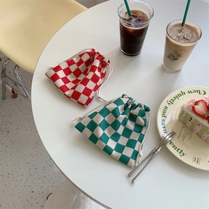 Detalle de bolsas de cuadros rojos y verdes con cordón en una mesa de té acogedora