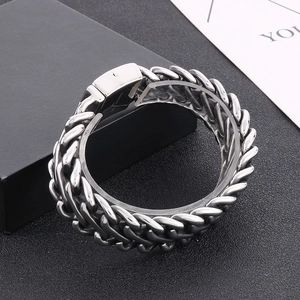 Detail of masculine braided stainless steel chain bracelet with rectangular clasp closure