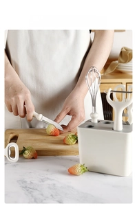 Detail of 6-piece kitchen tool set with storage base showing strawberry slicing with a knife